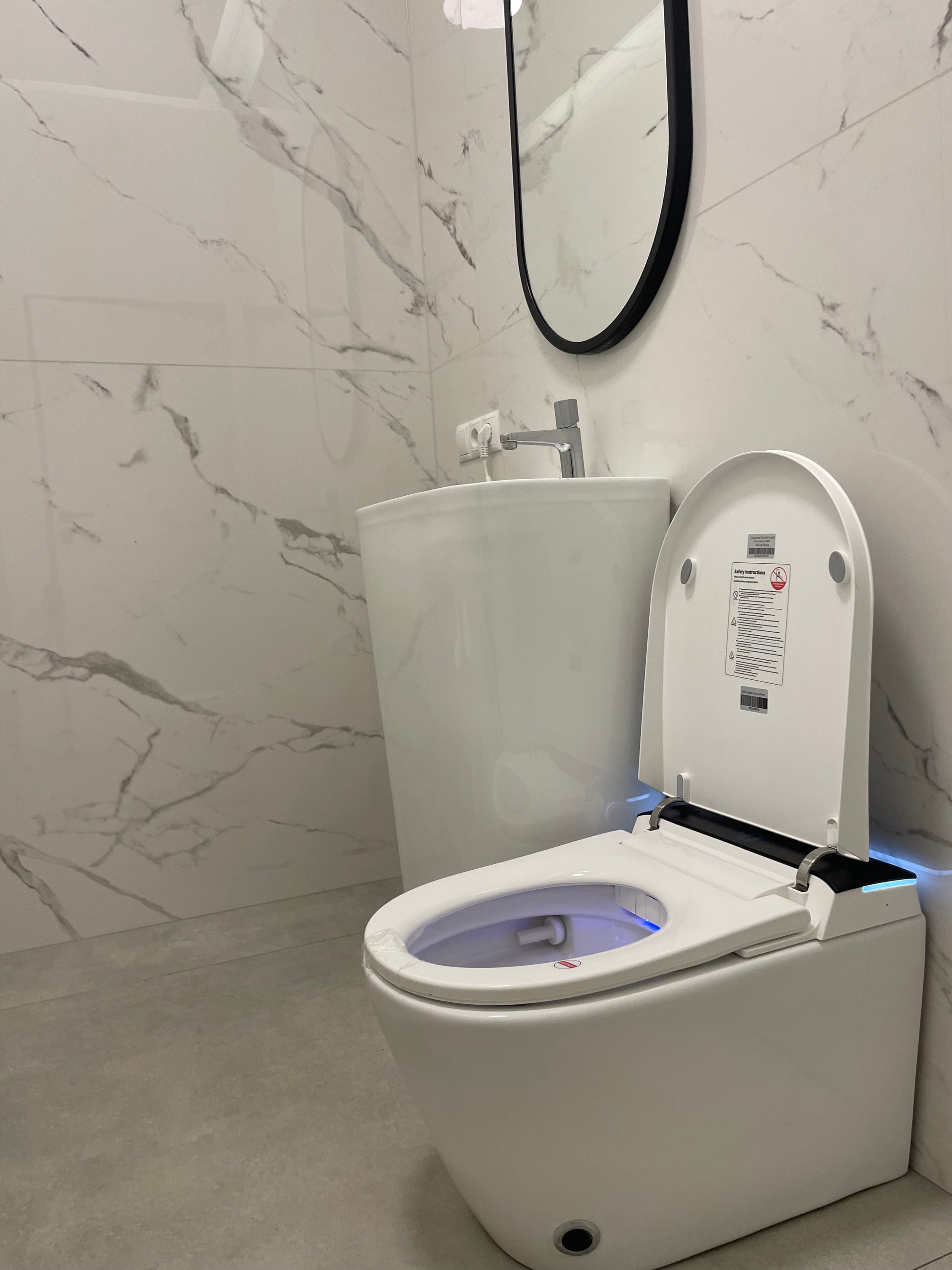 Modern Smart toilet Hola with buil-in tank, Geberit type frame with open lid in a bathroom with marble walls www.hola.shop.pl