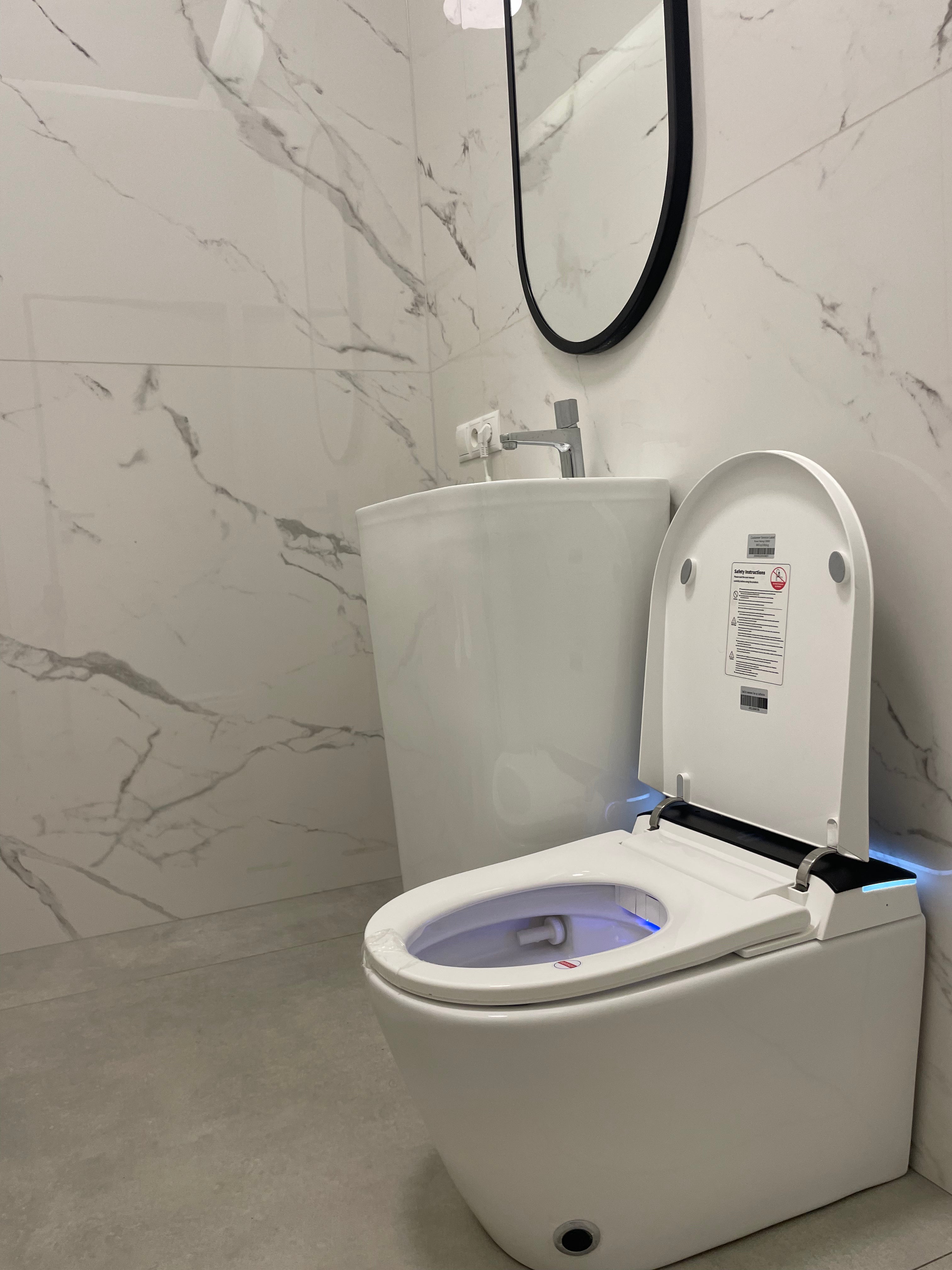 Modern Smart toilet Hola with buil-in tank, Geberit type frame with open lid in a bathroom with marble walls www.hola.shop.pl