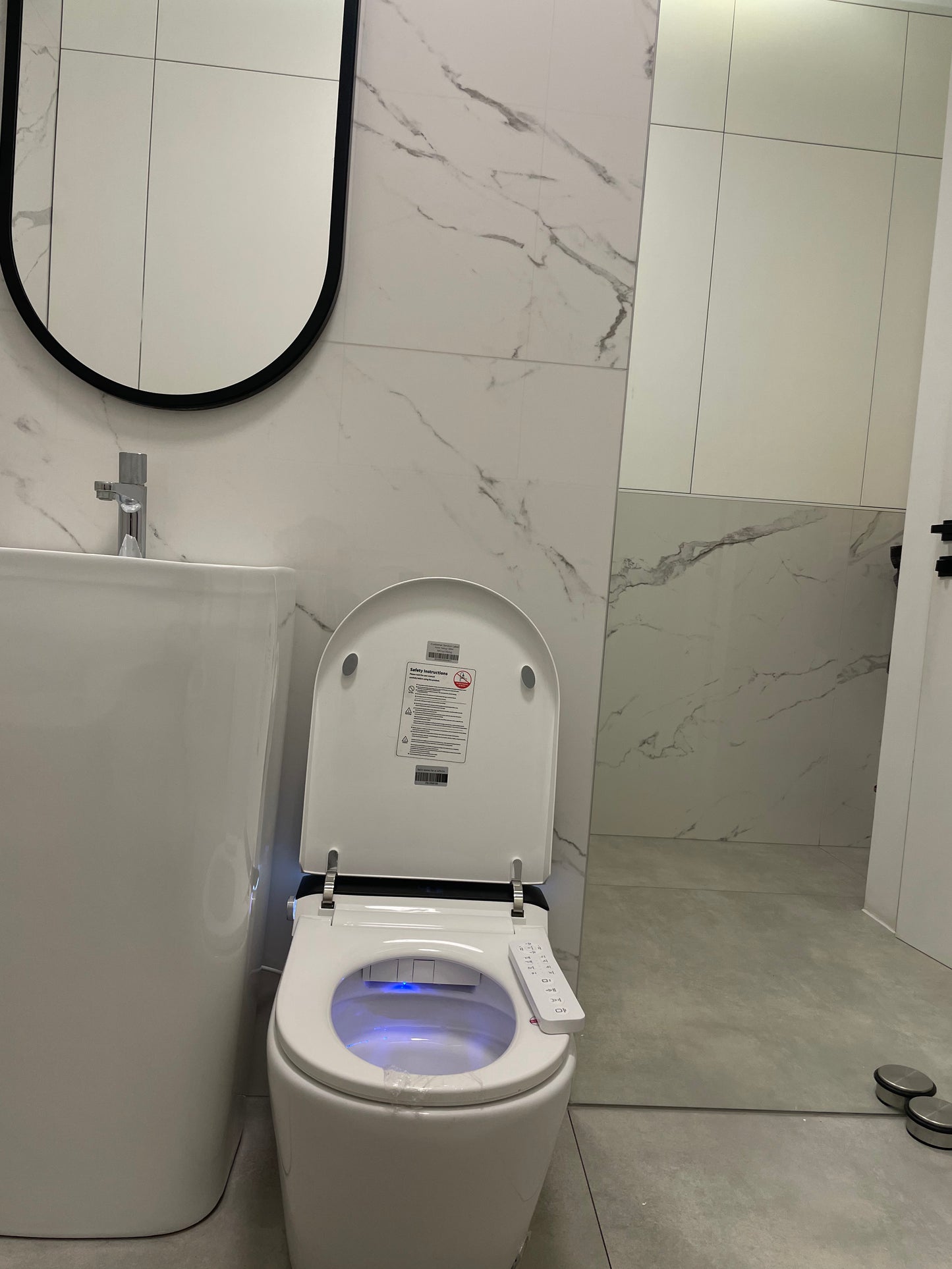 Smart toilet  Hola with buil-in tank, Geberit type frame with open lid in a bathroom setting www.hola.shop.pl