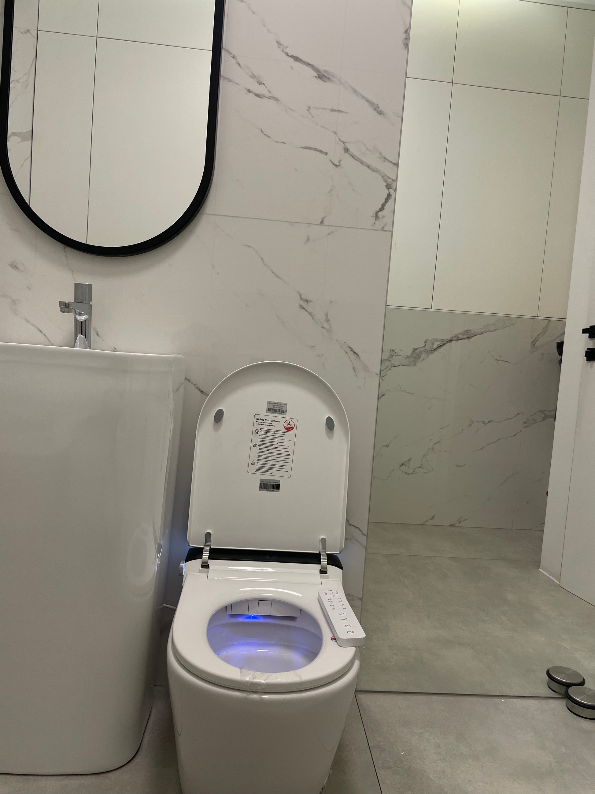 Smart toilet  Hola with buil-in tank, Geberit type frame with open lid in a bathroom setting www.hola.shop.pl